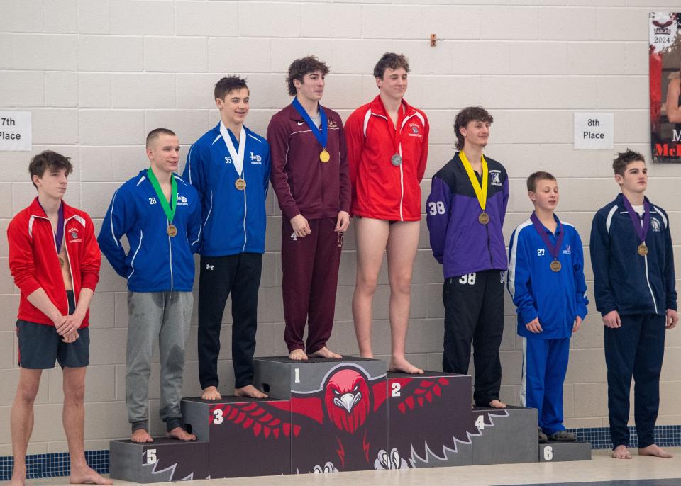 The eight medalists, including Spring Grove’s Elijah Henning, second from right, and Chambersburg’s Keagan Myers, right, pose on the medal stand made by Dover students.