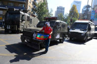 A demonstrator wearing a Guy Fawkes mask is seen next to riot police vehicles during a protest calling for changes in the education system in Santiago, Chile April 11, 2017. REUTERS/Ivan Alvarado