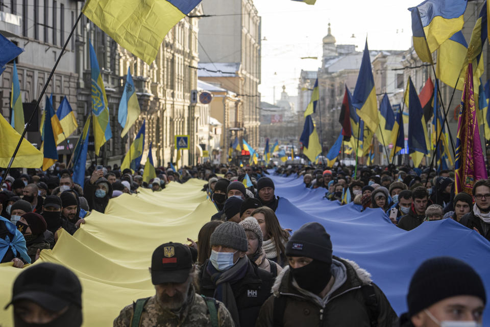 Demonstrators with Ukrainian national flags rally against Russian aggression in the center of Kharkiv, Ukraine's second-largest city, Saturday, Feb. 5, 2022, just 40 kilometers (25 miles) from some of the tens of thousands of Russian troops massed at the border of Ukraine. After weeks of talks in various diplomatic formats have led to no major concessions by Russia and the U.S., it's unclear how much impact the trips will have. But Ukraine's Foreign Minister Dmytro Kuleba said Friday that "top-level visits seriously reduce challenges in the sphere of security and upset the Kremlin's plans." (AP Photo/Evgeniy Maloletka)