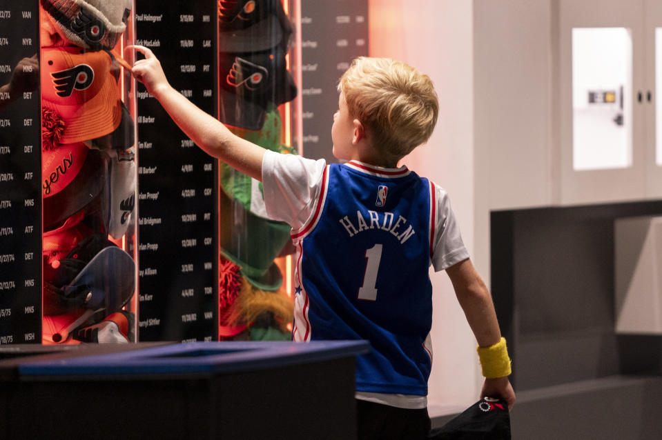 A young Philadelphia 76ers fan looks over a display while wearing a James Harden jersey prior to a preseason NBA basketball game against the Atlanta Hawks, Friday, Oct. 20, 2023, in Philadelphia. (AP Photo/Chris Szagola)