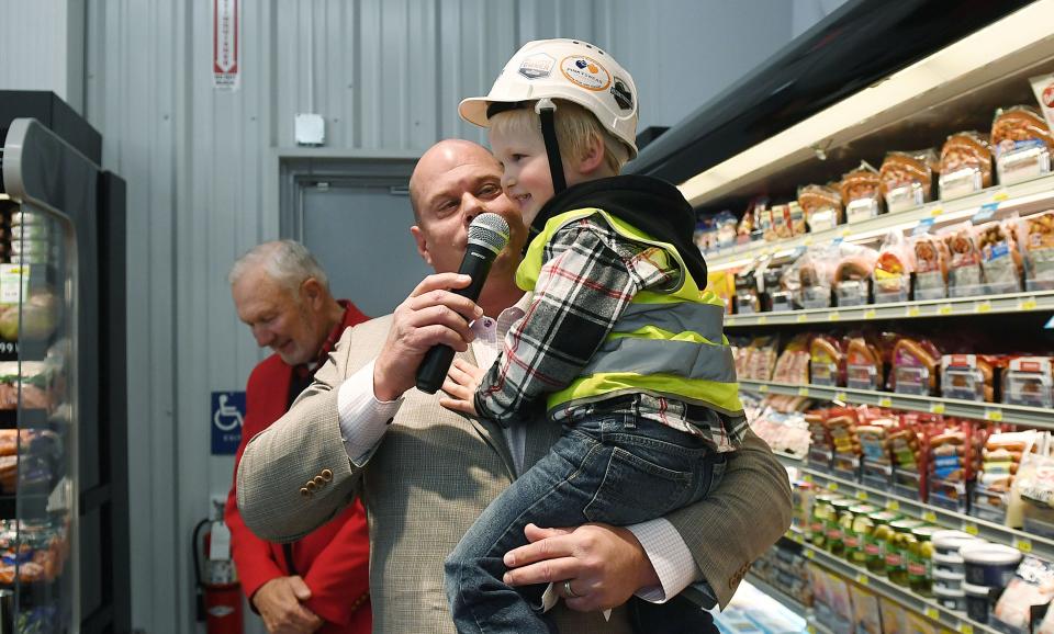 Three-year-old Clark Lage speaks as Fareway CEO Reynolds Cramer holds him during the new Ogden Fareway grand opening on Tuesday.
