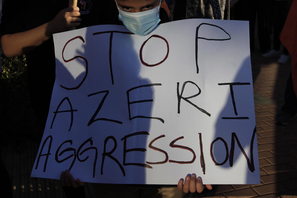 A boy holds a placard during a demonstration in support of Armenia outside of the U.S. embassy in the Cypriot capital Nicosia on Wednesday, Sept. 30, 2020. Armenian Cypriots took part in the demonstration to show their support for Armenian armed forces locked in heavy fighting with Azerbaijani forces over the separatist region of Nagorno-Karabakh. (AP Photo/Petros Karadjias)