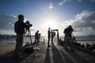 In this photo released by Tourism Queensland, people gather on a beach at Palm Cove in Queensland state, Australia, to watch and photograph a total solar eclipse Wednesday, Nov. 14, 2012. Starting just after dawn, the eclipse cast its 150-kilometer (95-mile) shadow in Australia's Northern Territory, crossed the northeast tip of the country and was swooping east across the South Pacific, where no islands are in its direct path. (AP Photo/Tourism Queensland, Murray Anderson-Clemence) EDITORIAL USE ONLY