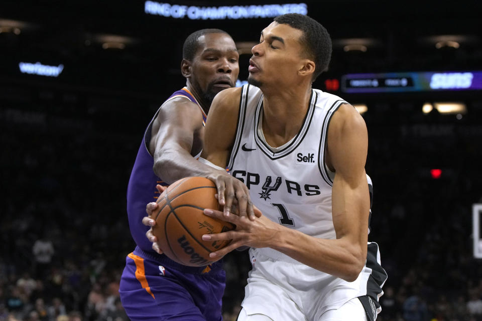 Phoenix Suns forward Kevin Durant fouls San Antonio Spurs center Victor Wembanyama (1) during the second half of an NBA basketball game Thursday, Nov 2, 2023, in Phoenix. (AP Photo/Rick Scuteri)