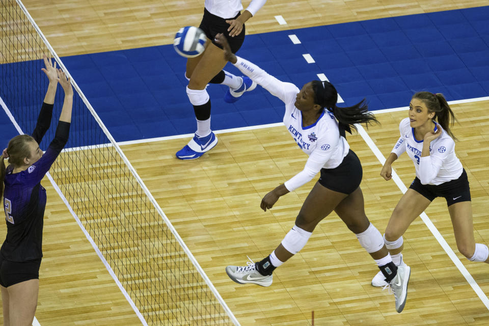 Kentucky middle blocker Azhani Tealer (15) spikes the ball against Washington middle blocker Marin Grote (12) in the first set during a semifinal in the NCAA women's volleyball championships Thursday, April 22, 2021, in Omaha, Neb. (AP Photo/John Peterson)