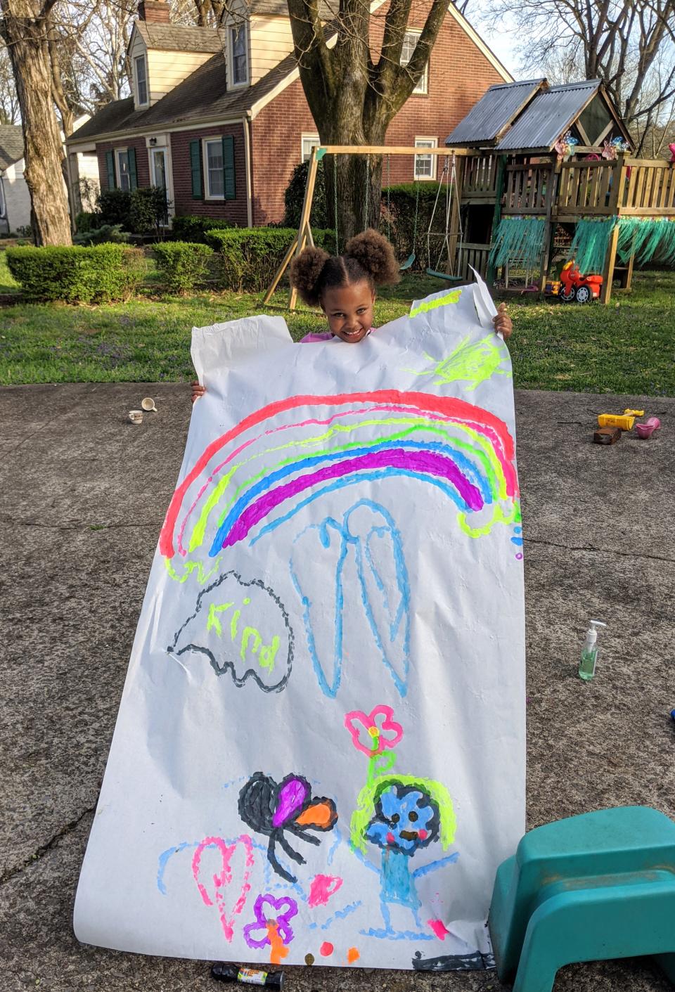 Kira with a drawing she created for her grandparents to look at from across the street. (Sherrie Neely)