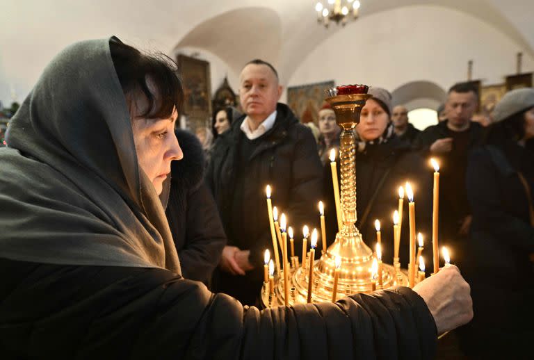 Una mujer enciende velas durante el servicio de Navidad en una iglesia de la Iglesia Ortodoxa de Ucrania en Kyiv el 25 de diciembre de 2022, en medio de la invasión rusa de Ucrania.