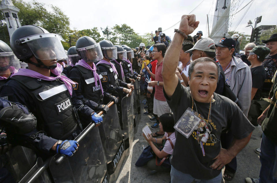 An anti-government protesters denounce riot police after they retook a protest site in Bangkok, Thailand, Friday, Feb. 14, 2014. Riot police cleared anti-government protesters from a major boulevard in the Thai capital in a small victory for authorities Friday as they try to reclaim areas that have been closed during a three-month push to unseat Prime Minister Yingluck Shinawatra. (AP Photo/Wally Santana)