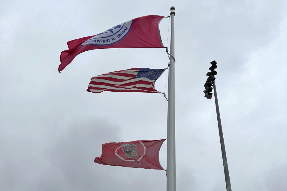 The flags of the Seneca Nation of Indians, Salamanca City Central School District and United States fly over the sports complex in Salamanca, New York, on April 18, 2023. The school district, located on Seneca Nation of Indians territory, may have to replace its logo after New York passed a ban on the use of Indigenous names, mascots and logos by public schools. (AP Photo/Carolyn Thompson)