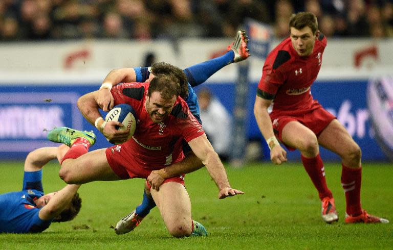 Wales' Jamie Roberts (C) is tackled by France's Morgan Parra during their Six Nations match on February 28, 2015 at the Stade de France