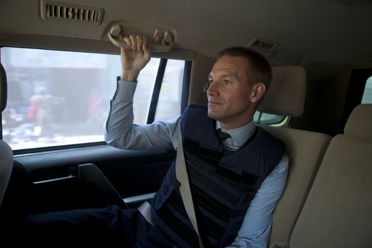 Britain's ambassador to Somalia, Neil Wigan, wears a flak jacket as he drives through Mogadishu in an armoured car on February 18, 2015