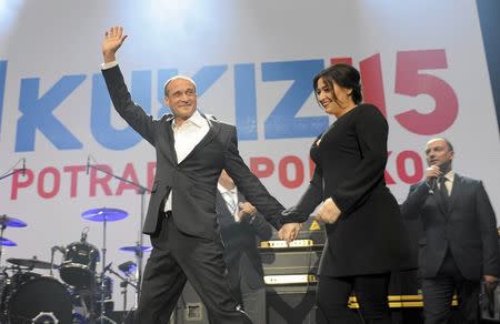 Pawel Kukiz (R) presidential candidate and former rock musician appears on stage with his wife Malgorzata (R) after the announcement of the first exit polls in the first round of the Polish presidential elections, at his election campaign headquarters in Lubin, Poland May 10, 2015. REUTERS/Kornelia Glowacka-Wolf/Agencja Gazeta