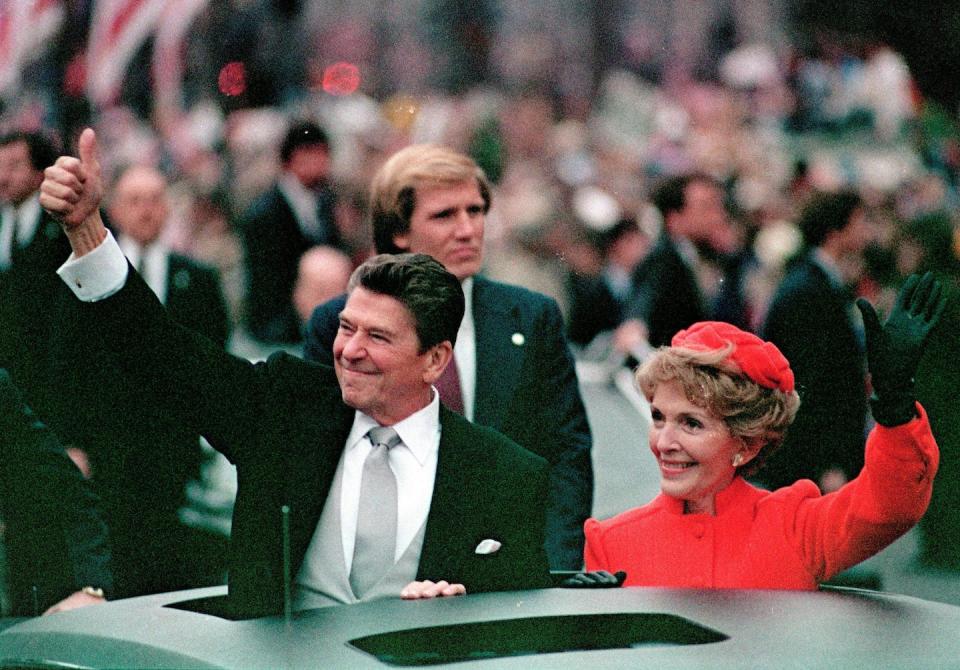 Ronald Reagan gives a thumbs up to the crowd while his wife, first lady Nancy Reagan, waves from a limousine during the inaugural parade in Washington following Reagan’s swearing in as the 40th president of the United States in January 1981. (AP Photo/File)