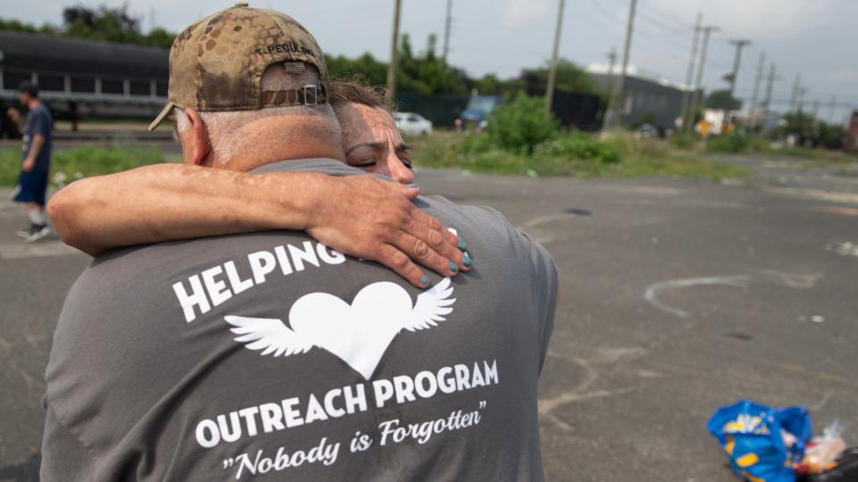 Tom Peculski, a retired EMT who leads Helping Hands Outreach Program, hugs Melanie, who has been on the streets since her husband died in 2017, after Melanie received food and personal hygiene items from members of the Helping Hands Outreach Program in Camden on July 18, 2023.