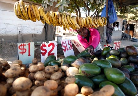 A street vendor sells vegetables at a market place in Chitungwiza, Zimbabwe