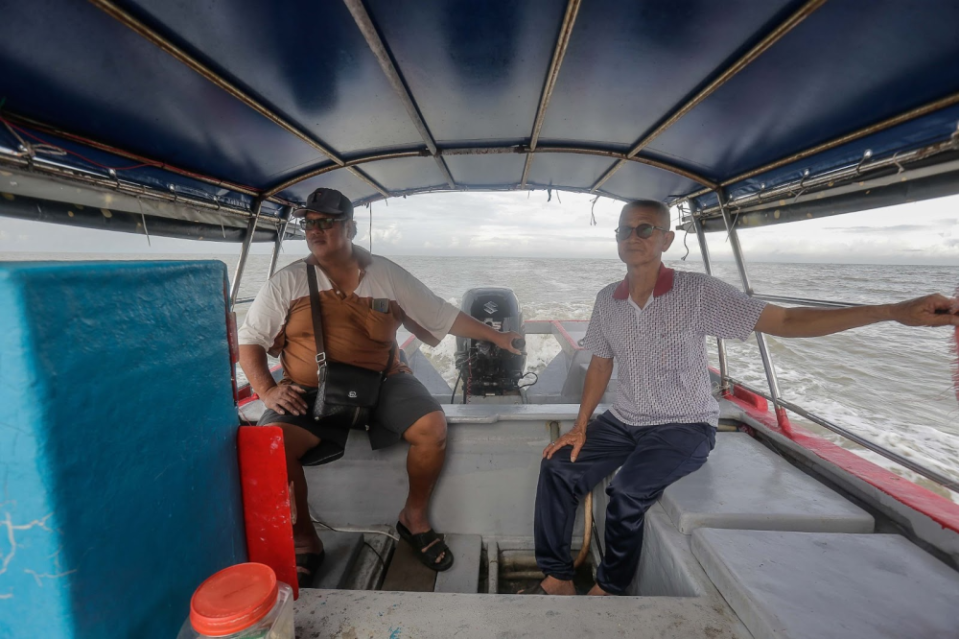 Lim Kee Hwa (left) and Zhang Guen Chi (right) at the back of their fishing boat. — Picture by Sayuti Zainudin