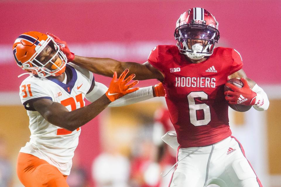 Indiana's Cam Camper stiff-arms Illinois' Devon Witherspoon at Memorial Stadium on Sept. 2, 2022.