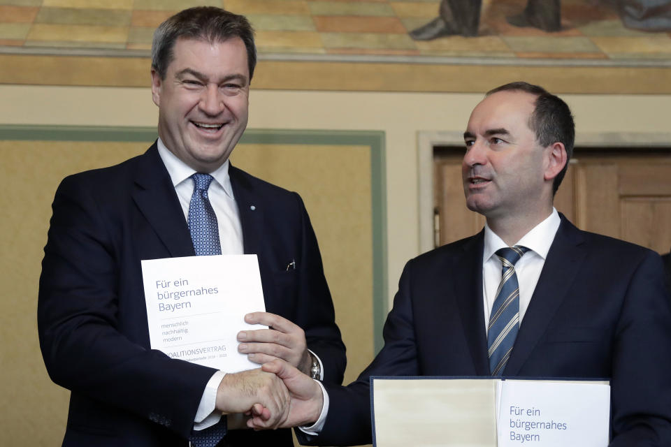 FILE - Bavarian State Governor Markus Soeder of the German Christian Social Union party CSU, left, and Hubert Aiwanger, chairman of the Free Voters in Bavaria, shake hands after signing the coalition contract in Munich, Germany, Monday, Nov. 5, 2018. The governor of Bavaria said Tuesday, Aug. 29, 2023 that his deputy has not done enough to substantiate he wasn't responsible for an antisemitic flyer as a high school student and ordered him to answer a detailed questionnaire to clear himself of any possible involvement in the scandal that caused an uproar in Germany. (AP Photo/Matthias Schrader, File)