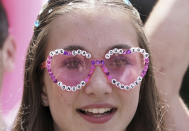 A fan wearing sunglasses waits outside Wembley Stadium ahead of Taylor Swift's first London concert, during her Eras Tour, in London, Friday June 21, 2024. (Lucy North/PA via AP)