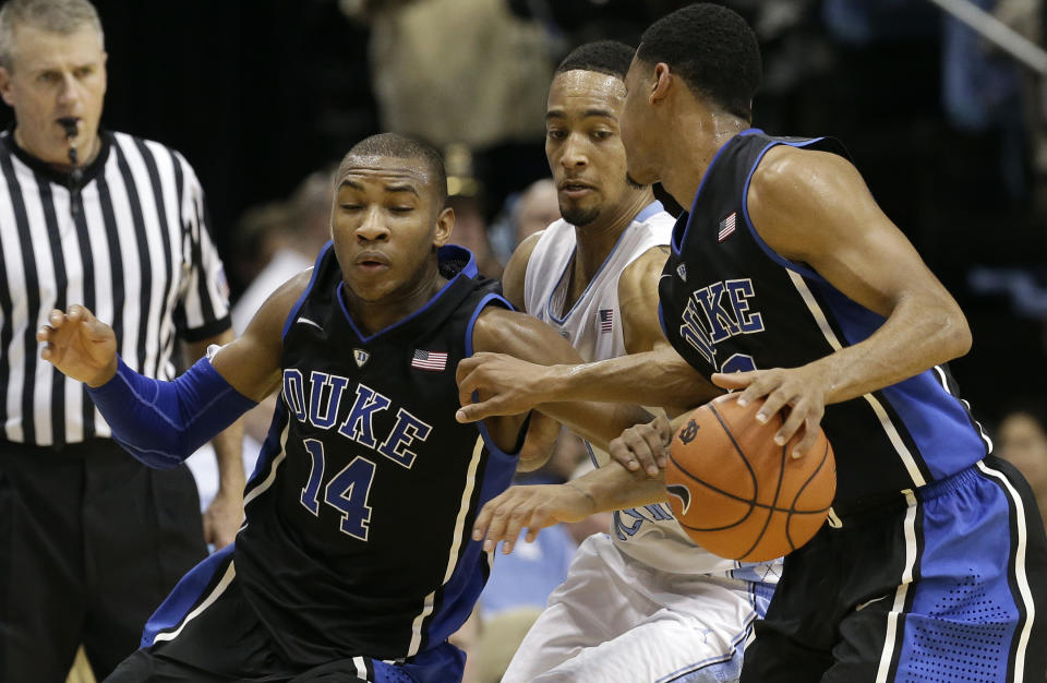 Duke's Rasheed Sulaimon (14) and Tyler Thornton, right, protect the ball from North Carolina's J.P. Tokoto, center, during the first half of an NCAA college basketball game in Chapel Hill, N.C., Thursday, Feb. 20, 2014. (AP Photo/Gerry Broome)