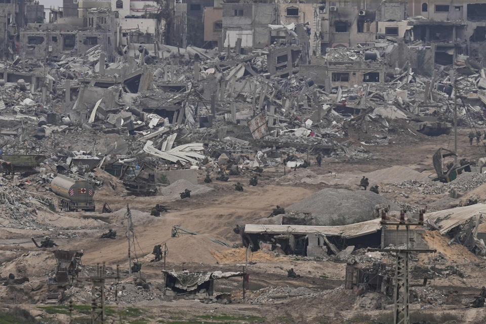 FILE - Israeli troops take positions in the Gaza Strip as seen from southern Israel, Thursday, Dec. 21, 2023. The army is battling Palestinian militants across Gaza in the war ignited by Hamas' Oct. 7 attack into Israel. South Africa has launched a case at the United Nations' top court alleging that Israel's military campaign in Gaza amounts to genocide. The filing and Israel's decision to defend itself at the International Court of Justice sets up a high-stakes showdown in the before a bench of the court's black-robed judges in the wood-panelled Great Hall of Justice. (AP Photo/Ohad Zwigenberg, File)