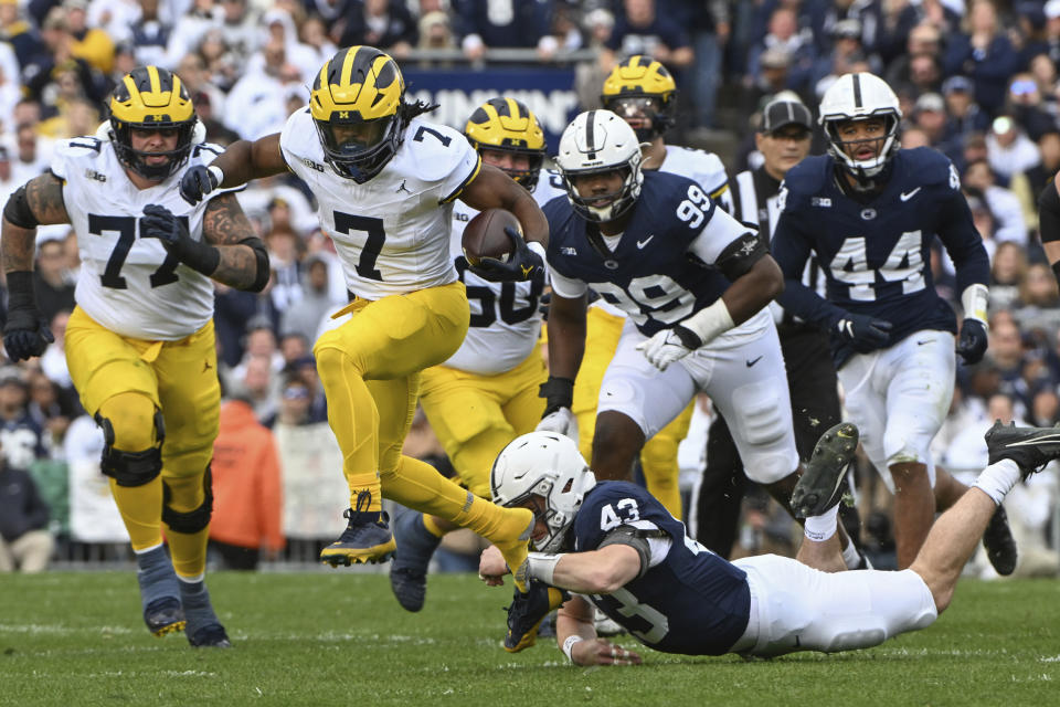 Michigan running back Donovan Edwards (7) gains yardage breaks a tackle attempt by Penn State linebacker Tyler Elsdon (43) during the first half of an NCAA college football game, Saturday, Nov. 11, 2023, in State College, Pa. (AP Photo/Barry Reeger)