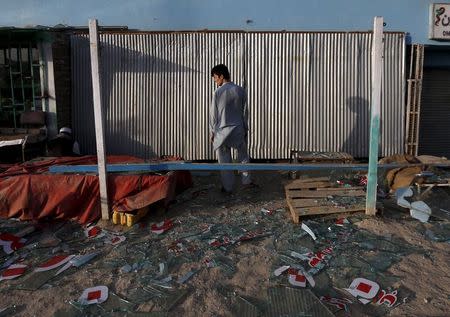 An Afghan man stands outside his damaged shop near the site of an attack after a overnight battle outside a base in Kabul, Afghanistan August 8, 2015. REUTERS/Mohammad Ismail