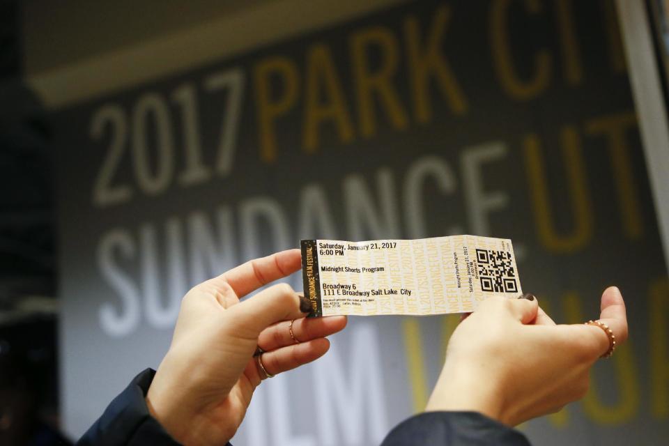 A festival goer holds up her movie ticket after visiting the Festival Box Office during the 2017 Sundance Film Festival on Saturday, Jan. 21, 2017, in Park City, Utah. Representatives for the Sundance Film Festival say that their network systems were subject to a cyberattack that caused its box offices to shut down briefly Saturday afternoon. (Photo by Danny Moloshok/Invision/AP)