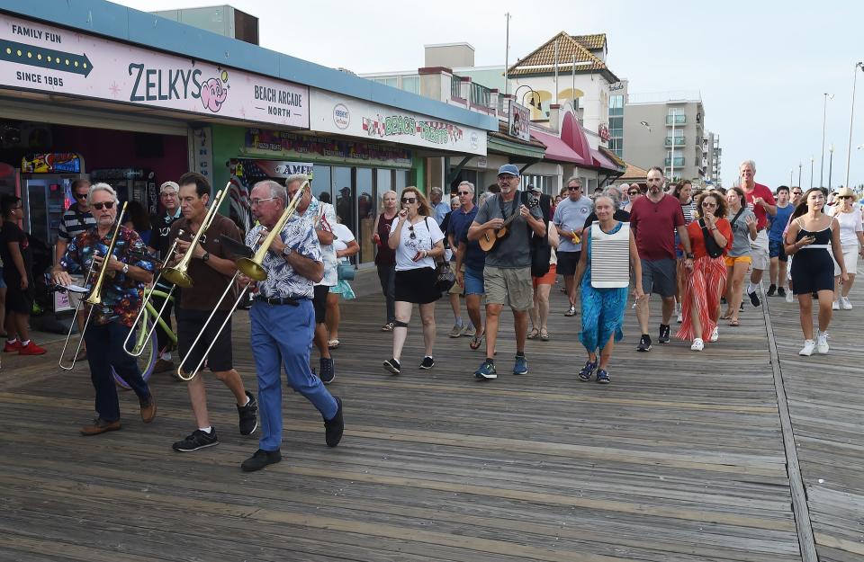 A band leads a crowd of people walked along the Rehoboth Beach Boardwalk on Labor Day in a ceremony marking the end of the 2022 summer season.