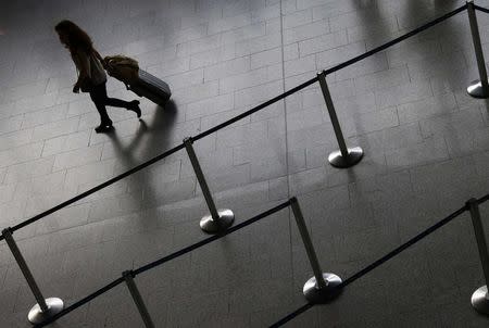 A flight passenger walks along an empty Lufthansa ticket counter during a strike at the Frankfurt airport, in Frankfurt September 5, 2014. REUTERS/Ralph Orlowski