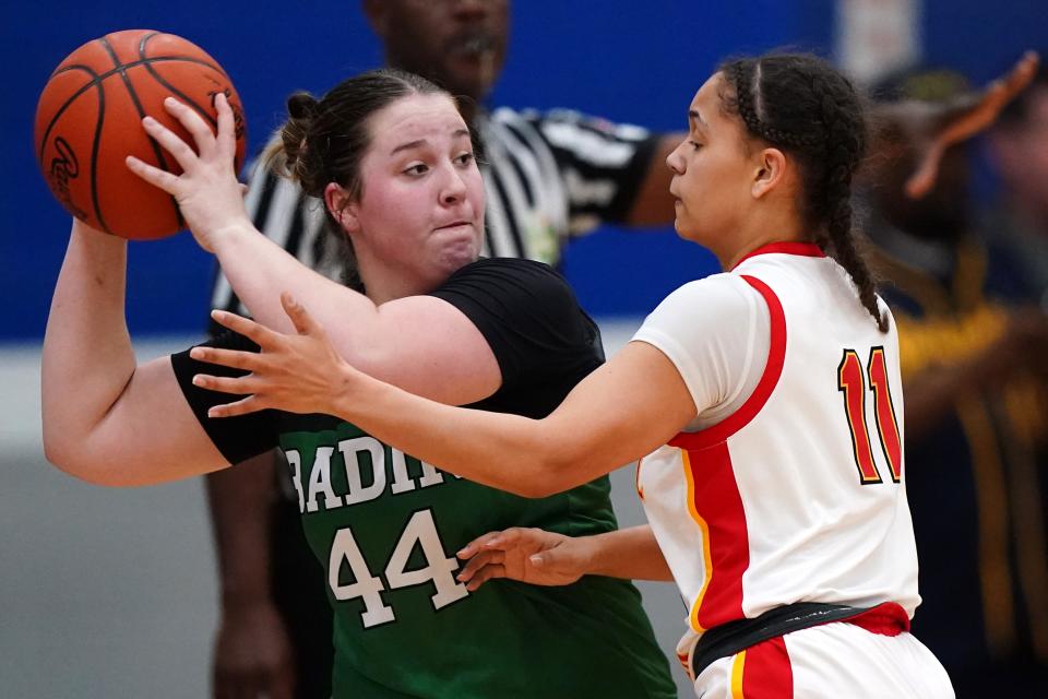 Badin’s Shelby Mulcare (44) looks to pass as Purcell Marian’s Trinity Small (11) defends in the first half of an OHSAA Division II girls regional final game March 8 at Springfield High School.