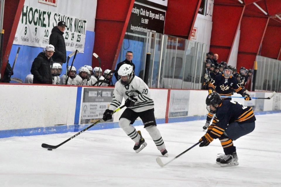 Abington's Hunter Grafton, left, skates against Cohasset/Hull's James Muldowney, right, during boys high school hockey at the Rockland Ice Rink, Monday, Feb. 12, 2024.