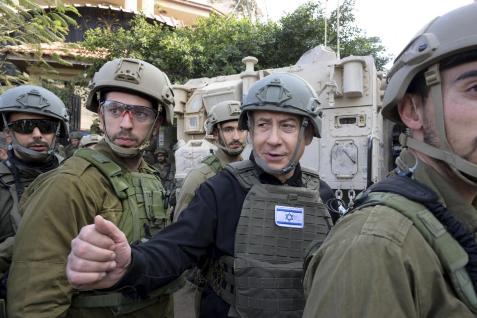 Israeli Prime Minister Benjamin Netanyahu, center, wears a protective vest and helmet as he receives a security briefing with commanders and soldiers in the northern Gaza Strip, on Monday, Dec. 25, 2023. (Avi Ohayon/GPO/Handout via AP)