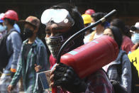 A protester carries a fire extinguish during an anti-coup demonstration in Mandalay, Myanmar, Saturday, March 6, 2021. The U.N. special envoy for Myanmar on Friday called for urgent Security Council action, saying about 50 peaceful protesters were killed and scores were injured in the military's worst crackdowns this week. (AP Photo)