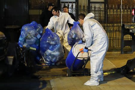 Members of a cleaning crew with "Bio Recovery Corporation" wearing personal protective equipment (PPE) push a barrel to be loaded in a truck of Centers for Disease Control and Prevention (CDC) after cleaning the apartment where Dr. Craig Spencer lives in New York October 24, 2014. REUTERS/Eduardo Munoz