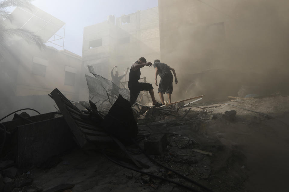 FILE - Palestinians look for survivors under the rubble of a destroyed building following an Israeli airstrike in Khan Younis refugee camp, southern Gaza Strip, Monday, Nov. 6, 2023. Entire generations of Palestinian families in the besieged Gaza Strip have been killed in airstrikes in the ongoing Hamas-Israel war. They include infants to elderly grandparents, killed in attacks the Israeli army says aim to root out the militant group from the densely populated coastal territory. (AP Photo/Mohammed Dahman, File)