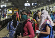 Women passengers wait for a local train in Mumbai, India, Wednesday, Oct. 21, 2020. Indian railways has permitted women passengers to travel in local trains during non-peak hours beginning Wednesday, which otherwise has been running only for essential services. (AP Photo/Rajanish Kakade)