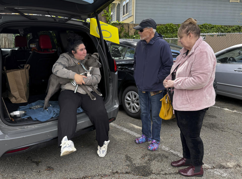 A couple meets a dog available for adoption at Oakland Animal Services on Thursday, April 4, 2024, in Oakland, Calif. The city animal shelter has seen a surge in pets surrendered by tenants who can't find rentals that allow pets. A bill in California wants to make more rental housing available to tenants with pets. (AP Photo/Terry Chea)