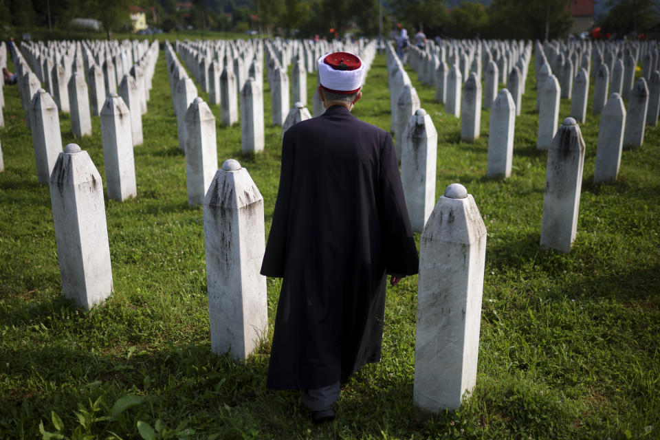 Bosnian muslim effendi walks through the memorial cemetery in Potocari, Bosnia, Tuesday, July 11, 2023 prior to the mass burial of newly identified victims of the Srebrenica genocide. Thousands gather in the eastern Bosnian town of Srebrenica to commemorate the 28th anniversary on Monday of Europe's only acknowledged genocide since World War II. (AP Photo/Armin Durgut)