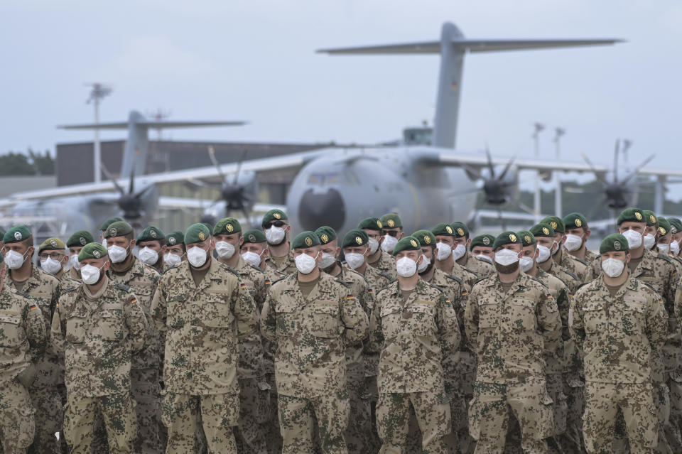 Soldiers of the German Armed Forces have lined up in front of the Airbus A400M transport aircraft of the German Air Force for the final roll call in Wunstorf, Germany, Wednesday, June 30, 2021. The last soldiers of the German Afghanistan mission have arrived at the air base in Lower Saxony. The mission had ended the previous evening after almost 20 years. The soldiers had been flown out with four military planes from the field camp in Masar-i-Sharif in the north of Afghanistan. (Hauke-Christian Dittrich/Pool via AP)