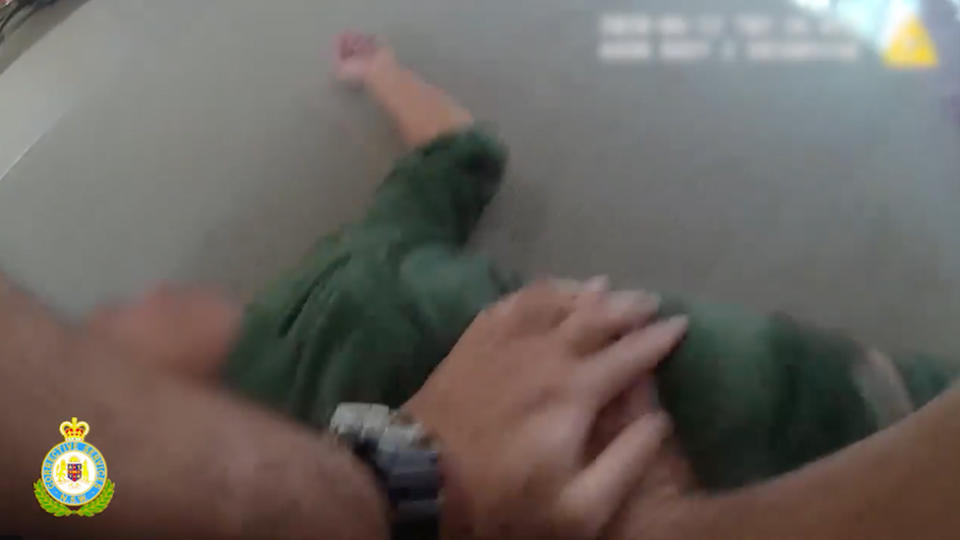 Body-camera still of an officer performing CPR on a female inmate.