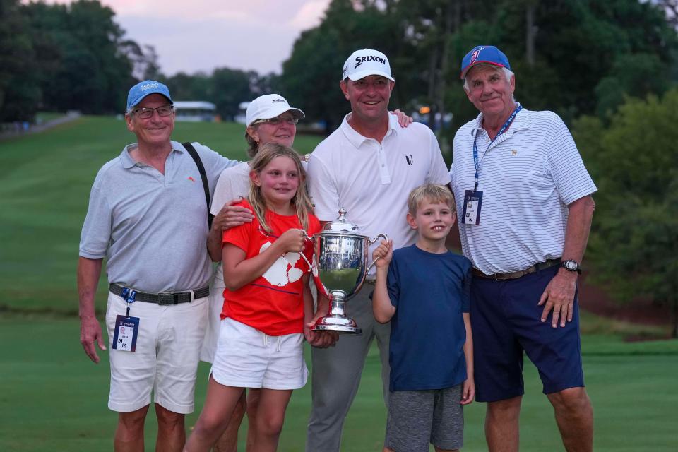 Lucas Glover, center, poses with his family and the champions trophy after winning the Wyndham Championship, Sunday in Greensboro, North Carolina.