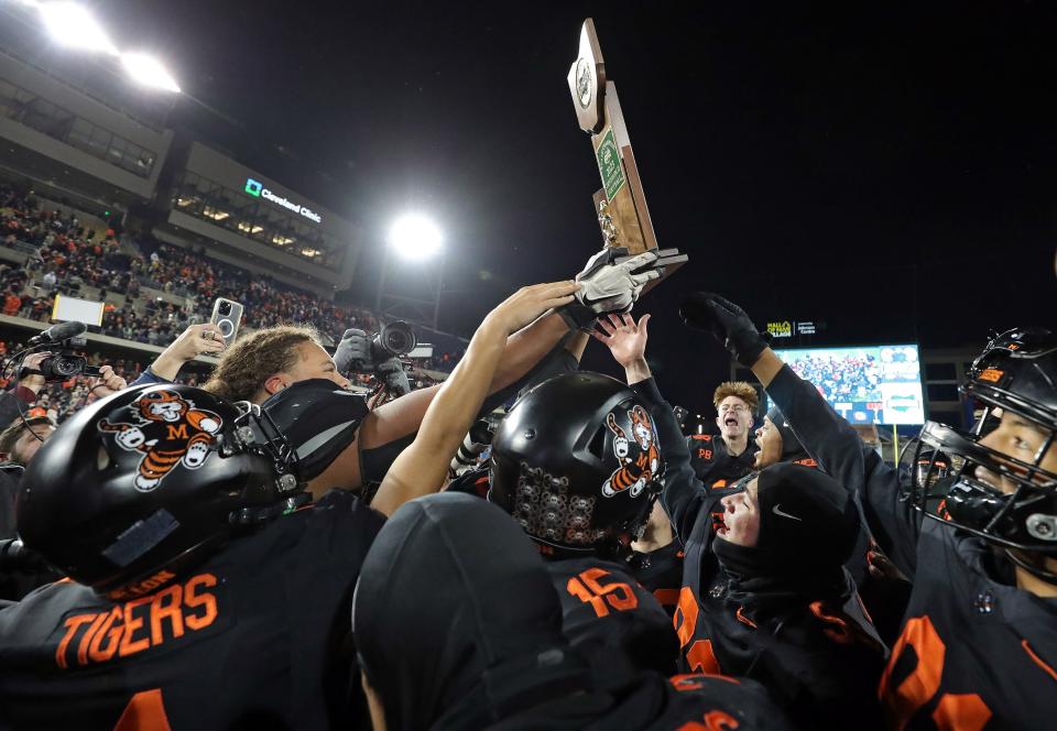 The Massillon Tigers celebrate with the trophy after beating Hoban in the OHSAA Division II state championship game Thursday.