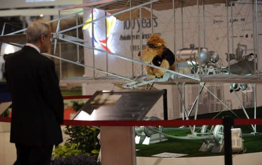 A visitor looks at a stainless steel replica of the Bristol Boxkite displayed at Singapore Airshow in Singapore on February 16, 2012. Some 900 exhibiting companies from over 50 countries including top global aerospace companies participated in the event