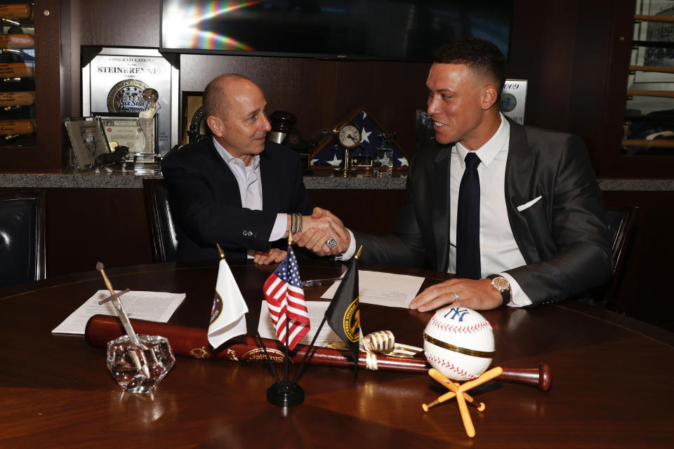 NEW YORK, NY - DECEMBER 21: General manager Brian Cashman of the New York Yankees and Aaron Judge #99 finalize Judges nine-year contract before a press conference at Yankee Stadium on December 21, 2022 in the Bronx, New York. (Photo by New York Yankees/Getty Images)