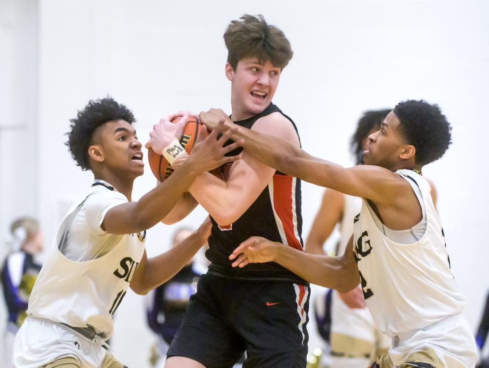 SH-G's Bryce Musgrave, left, and J'veon Bardwell, right, double up on Metamora's Matthew Zobrist in the first half Monday, Jan. 16, 2023 at UI-Springfield. The Redbirds defeated the defending 3A state champion Cyclones 60-50.