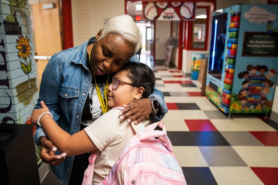 Ashley Soto, a third grader at Cora Kelly Elementary in Alexandria, Va., hugs Andrea Hill, literacy instructional coach, during her last day of school.