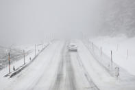 A car makes his way after snow fall near Altenberg, Germany, Sunday, Feb. 7, 2021. (AP Photo/Matthias Schrader)