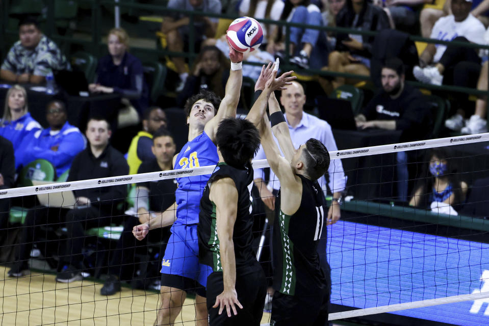 Hawaii opposite hitter Dimitrios Mouchlias (11) and Eleu Choy (5) attempt to block UCLA outside hitter Ethan Champlin (20) during a match in the NCAA college men's volleyball tournament, Saturday, May 6, 2023, in Fairfax, Va. (Julia Nikhinson/Honolulu Star-Advertiser via AP)