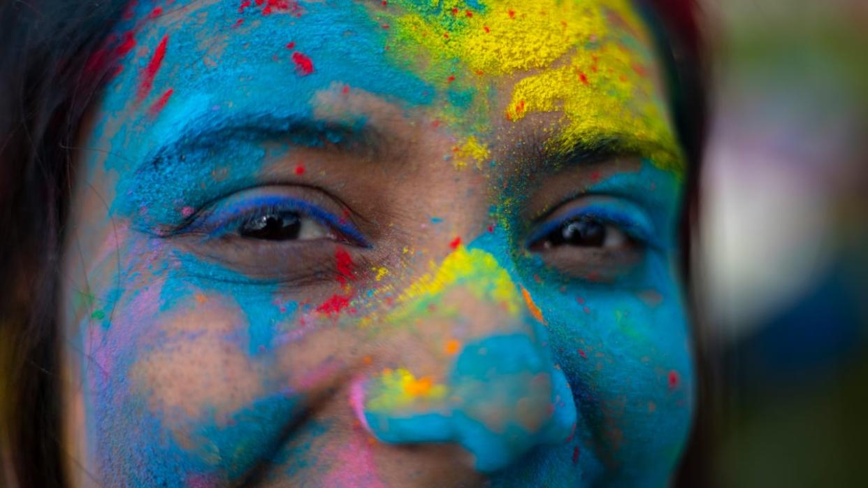 Dharti Patel is covered in coloured powders to celebrate Holi at an event in Brandon, Man., in 2023 in this file photo. A Holi event will be held on Saturday at the Kitchener Public Library. (Chelsea Kemp/CBC - image credit)